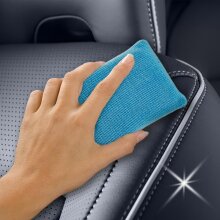 Ein Autositz wird mit einem Autoschwamm gereinigt.
